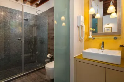 a bathroom with a shower and a sink and a toilet at Rodos Niohori Elite Suites Boutique Hotel in Rhodes Town