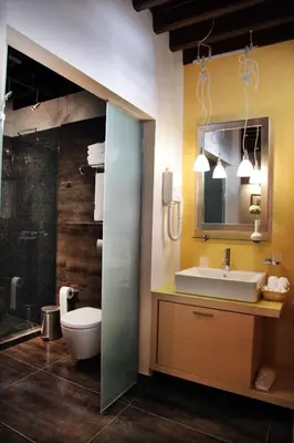 a bathroom with a sink and a toilet and a mirror at Rodos Niohori Elite Suites Boutique Hotel in Rhodes Town