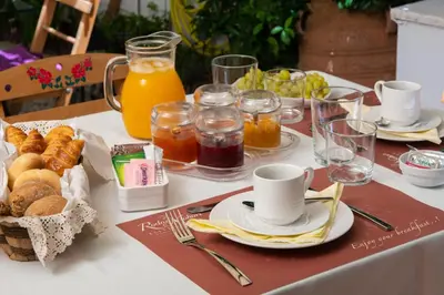 a table with a breakfast of orange juice and pastries at Rodos Niohori Elite Suites Boutique Hotel in Rhodes Town