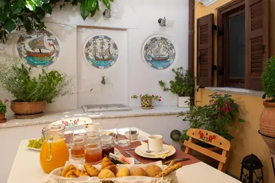 a table with bread and drinks and plates of food at Rodos Niohori Elite Suites Boutique Hotel in Rhodes Town