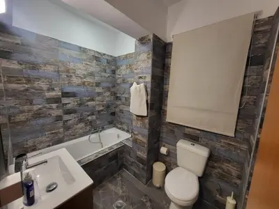 a bathroom with a toilet and a sink and a tub at Villa Rose on the beach in Afantou