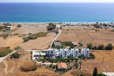 an aerial view of a building near the ocean at Villa Rose on the beach in Afantou
