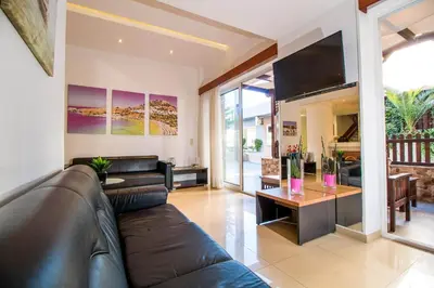 a living room with a leather couch and a table at Filmar Hotel, Ixia, Rhodes in Ixia