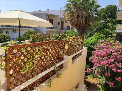 a fence with pink flowers and an umbrella at Italian flair with a view in Rhodes Town