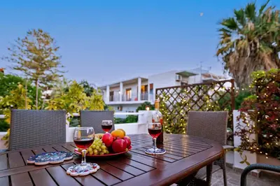 a table with two glasses of wine and a bowl of fruit at Italian flair with a view in Rhodes Town