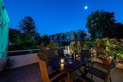 a table and chairs on a balcony at night at Italian flair with a view in Rhodes Town