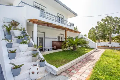 a white house with plants on the steps at Toulas Studios & Apts No2 in Faliraki