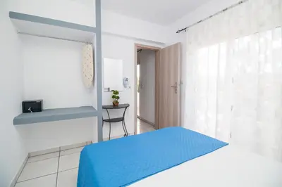 a bedroom with a blue bed and a window at Toulas Studios & Apts No2 in Faliraki