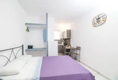 a bedroom with a bed and a clock on the wall at Toulas Studios & Apts No2 in Faliraki