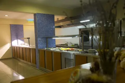 a restaurant kitchen with a counter with food at Ekaterini Hotel in Kiotari