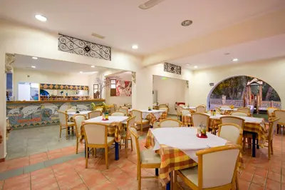 a restaurant with tables and chairs in a room at Ekaterini Hotel in Kiotari