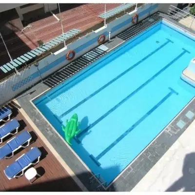 a large swimming pool with a blue pool at Helena Hotel in Rhodes Town