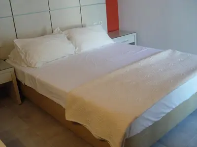 a bed with white sheets and pillows in a room at Helena Hotel in Rhodes Town