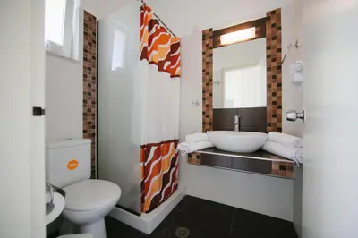 a bathroom with a sink and a toilet and a mirror at Artemis Comfort&Pleasure in Faliraki