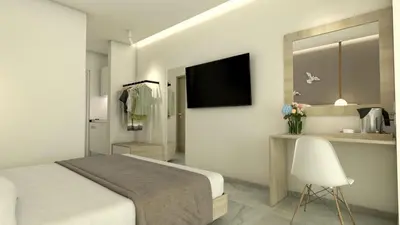 a bedroom with a bed and a desk with a television at Artemis Comfort&Pleasure in Faliraki