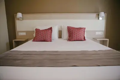 a bed with two red pillows on top of it at Artemis Comfort&Pleasure in Faliraki