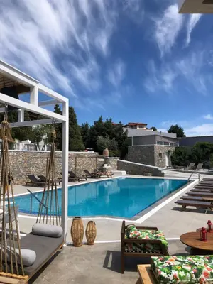a large swimming pool with chairs and a patio at Johannes Boutique Apartments & Suites in Afantou