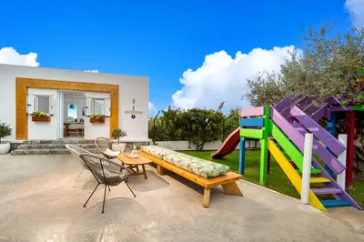 a backyard with a slide and a table and chairs at Johannes Boutique Apartments & Suites in Afantou