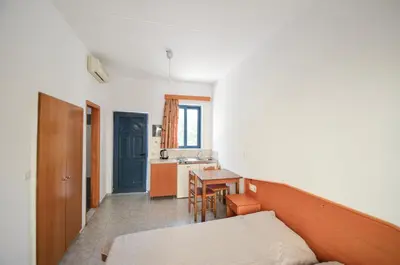a small room with a bed and a kitchen at Stegna Star Apartments in Archangelos