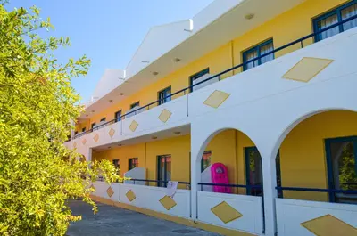 an exterior view of a building with yellow and white at Stegna Star Apartments in Archangelos