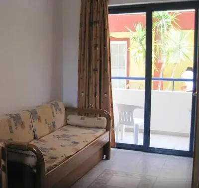 a living room with a couch and a sliding glass door at Stegna Star Apartments in Archangelos