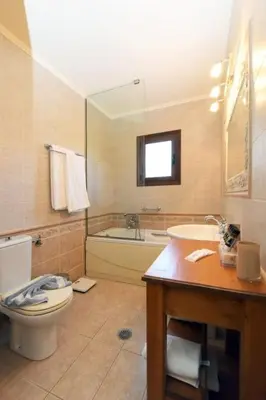 a bathroom with a toilet and a tub and a sink at Paris Hotel in Rhodes Town