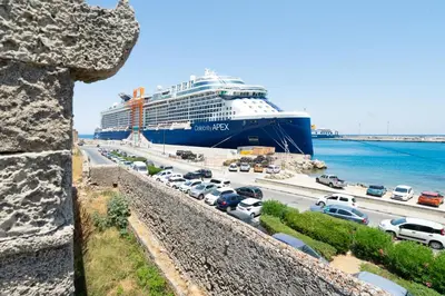 a cruise ship docked at a harbor with cars parked at Cava d'Oro in Rhodes Town