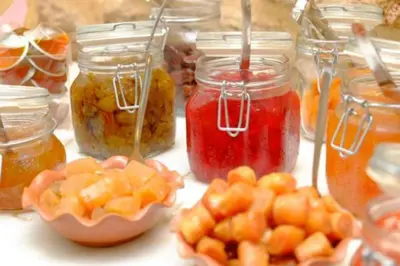a table topped with jars of jam and fruit at Cava d'Oro in Rhodes Town