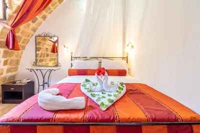 a bedroom with a bed with a flower on it at Cava d'Oro in Rhodes Town