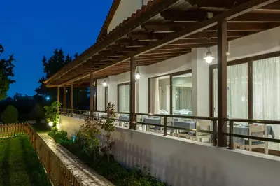 a house with a balcony at night at Matoula Beach in Ialyssos