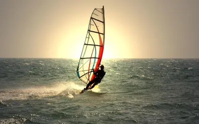 a man windsurfing in the ocean on the water at Matoula Beach in Ialyssos