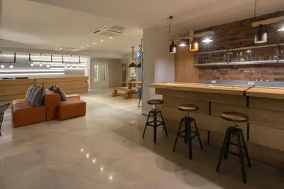 a lobby with a bar with a couch and chairs at Matoula Beach in Ialyssos