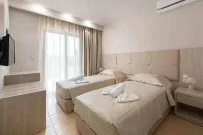 a hotel room with two beds and a window at Saint George Resort in Archangelos