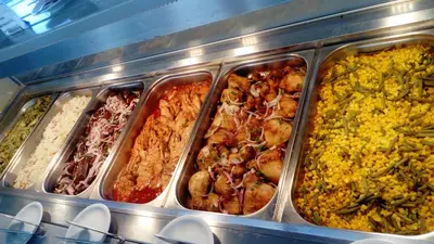 a buffet of different types of food in containers at Saint George Resort in Archangelos