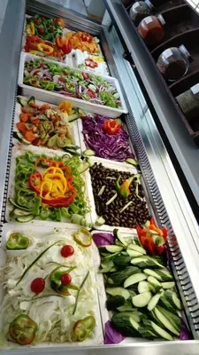 a display case filled with different types of vegetables at Saint George Resort in Archangelos