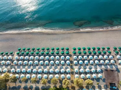 an aerial view of a beach with a lot of umbrellas at Esperos Palace Resort & Spa in Faliraki