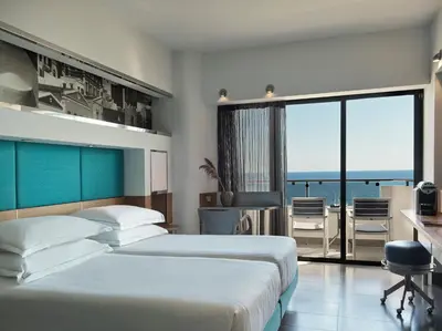 two beds in a room with a view of the ocean at Esperos Palace Resort & Spa in Faliraki