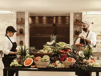 two chefs standing in front of a display of fruit at Esperos Palace Resort & Spa in Faliraki