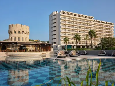 a hotel with a pool in front of a building at Esperos Palace Resort & Spa in Faliraki
