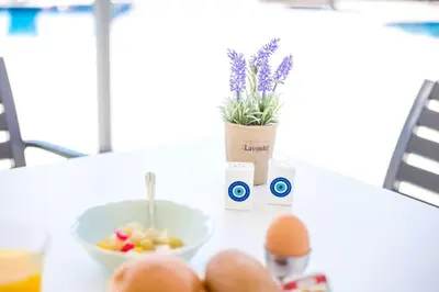 a table with eggs a bowl of fruit and a plant at Madison Boutique, Faliraki in Faliraki