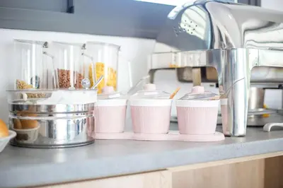 a row of pink cups sitting on a kitchen counter at Madison Boutique, Faliraki in Faliraki