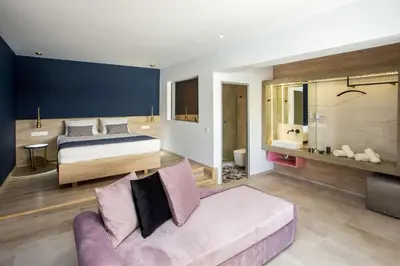 a bedroom with a bed and a couch in a room at Madison Boutique, Faliraki in Faliraki