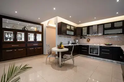 a kitchen with a table and chairs in it at Maia Luxury Pool Villa in Afantou