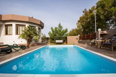 a swimming pool in the backyard of a house at Maia Luxury Pool Villa in Afantou