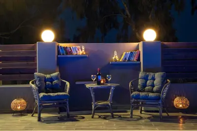 two chairs and a table with a bottle of wine at Maia Luxury Pool Villa in Afantou
