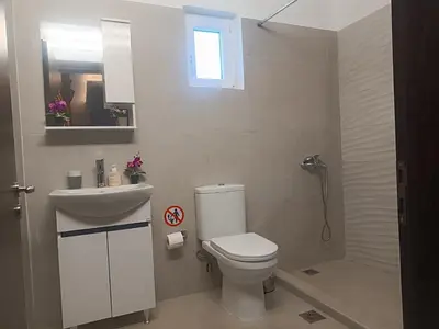 a bathroom with a toilet and a sink and a mirror at Maia Luxury Pool Villa in Afantou