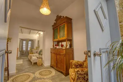 a hallway with a large wooden cabinet and chairs at Mascot Boutique Hotel in Rhodes Town