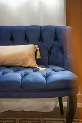 a blue couch with a pillow on top of it at Mascot Boutique Hotel in Rhodes Town