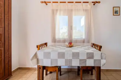 a dining room table with a checkered table cloth at Maria Apartments in Pefki Rhodes