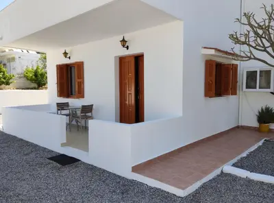 a white house with a dining room and a table at Maria Apartments in Pefki Rhodes